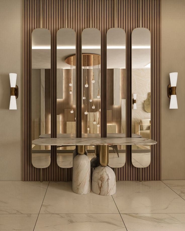 An elegant and contemporary console table featuring a luxurious white marble tabletop with grey veining. The table is supported by two substantial, rounded marble bases with brass accents. Integrated into the design is a tall, decorative screen composed of multiple vertical, rounded-edge panels, likely made of frosted glass or acrylic, framed in polished brass. A horizontal brass bar connects the top of these panels, unifying the structure. The overall aesthetic is one of sophisticated modernism with Art Deco influences, designed to serve both as a display surface and a subtle room divider. — 3D model