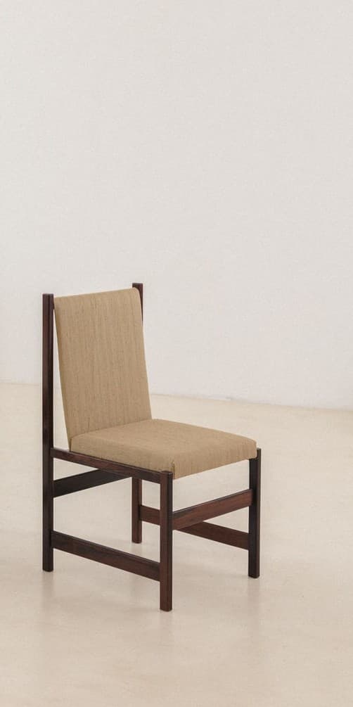 A wooden chair with a high, rectangular back and a seat, both upholstered in a textured, light brown fabric. The frame is constructed from dark, stained wood with clean lines and a minimalist design. The legs are sturdy and angular, connected by horizontal supports. — 3D model