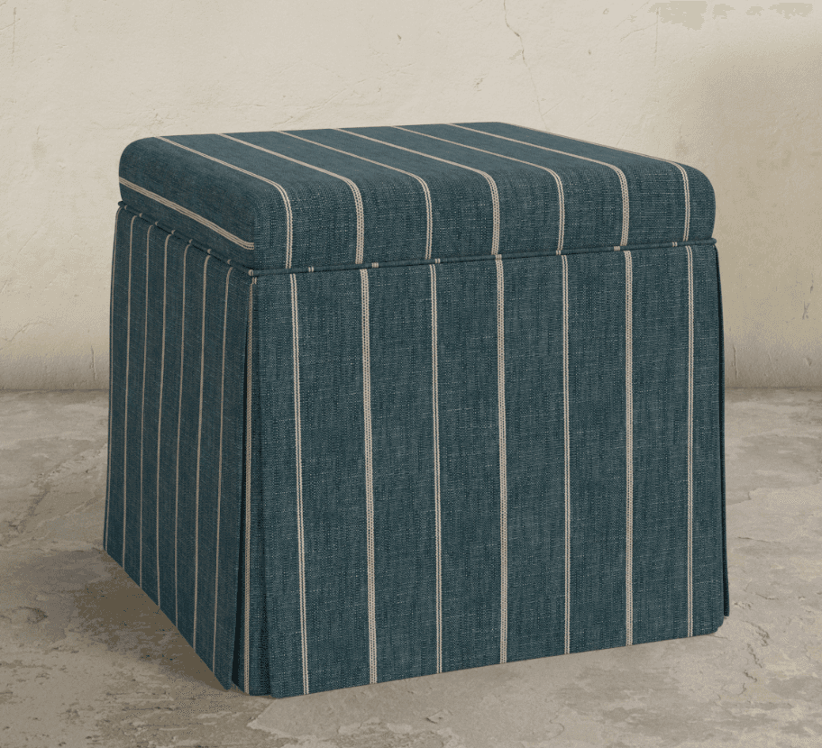 A square, upholstered ottoman featuring a pleated skirt that extends to the floor. The fabric is a dark teal with thin, light-colored vertical stripes. The top cushion is slightly rounded at the edges. — 3D model