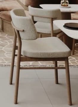 An armless dining chair featuring a light-colored wooden frame and fully upholstered seat and backrest in a light beige, textured fabric. The backrest has a gentle curve for ergonomic support, and the legs are slender and tapered. The overall design is clean, modern, and minimalist. — 3D model