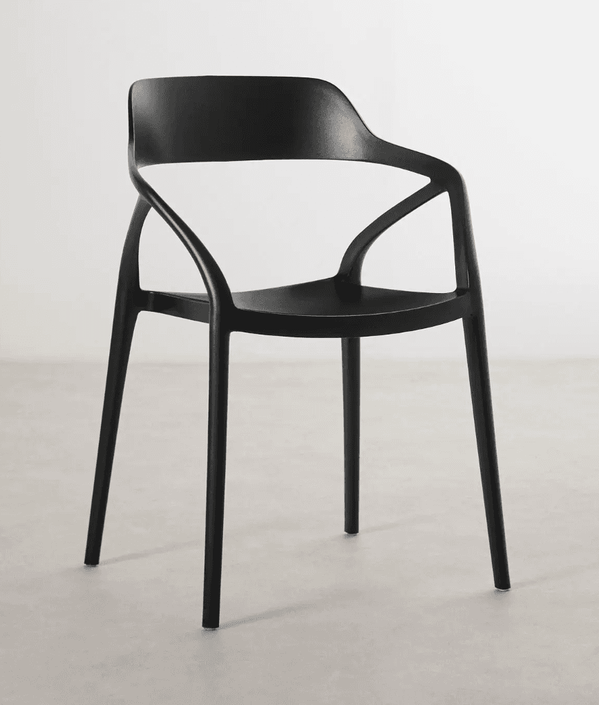 A modern armchair with a molded, single-piece seat and backrest, supported by four slender legs. The armchair features integrated armrests that curve elegantly from the backrest. The design is minimalist and appears to be constructed from a durable, lightweight material suitable for both indoor and outdoor use. — 3D model