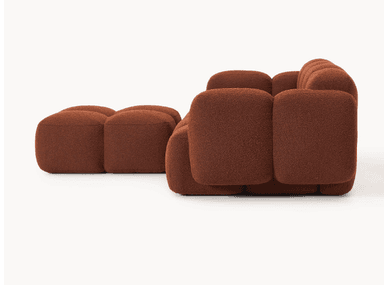 A modular sofa with a rounded, organic silhouette. The sofa is composed of several individual cubic modules that are upholstered in a textured, bouclé fabric. The arrangement suggests a sectional configuration, possibly an L-shape, with distinct seat and backrest sections, and padded armrests. The overall design is characterized by its plush, pillow-like appearance and low profile. — 3D model
