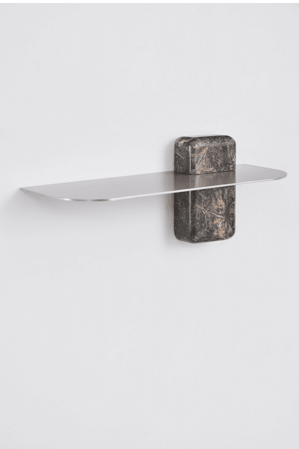 A minimalist wall-mounted shelf featuring a sleek, rectangular metallic surface supported by two robust, rounded blocks of variegated natural stone. The shelf has rounded edges, giving it a soft, contemporary appearance. The stone supports are positioned symmetrically, with one visible on top of the shelf and one below, giving the impression that the shelf is held between them. The overall aesthetic is modern and sophisticated. — 3D model
