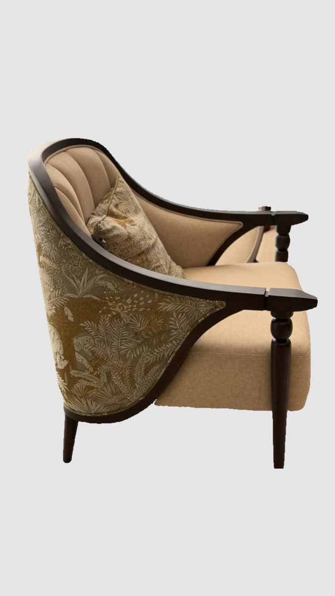 An upholstered armchair featuring an exposed dark wooden frame, a curved backrest with inner fluting, and outer patterned fabric. It includes a solid-colored seat cushion and a matching decorative pillow. — 3D model