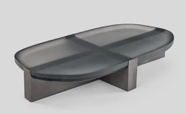 A contemporary coffee table featuring an oblong, dark translucent (smoked glass or acrylic) top with smoothly rounded edges, supported by a central, rectangular base made of a dark-finished material, likely metal or wood. The overall aesthetic is minimalist and sleek. — 3D model