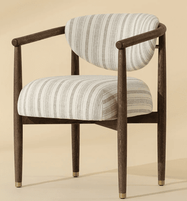 An armchair with a wooden frame and upholstered seat and back. The frame has a dark wood finish with a visible grain. The seat and back are upholstered in a fabric with a vertical stripe pattern in white and grey. The arms are curved and extend from the backrest to the front legs. The legs are tapered and capped with brass accents. — 3D model