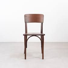 A wooden chair with a curved backrest and a padded seat. The chair has four legs and appears to be of vintage design. The wood is stained a dark brown, and the seat is upholstered in a dark fabric. — 3D model