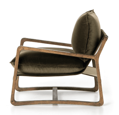 A rustic-style armchair featuring a robust, dark-stained wooden frame with thick, plush olive green velvet cushions for the seat and backrest. The frame has a simple, somewhat blocky construction, with visible wood grain and exposed armrests. The cushions are generously padded, providing a comfortable and inviting appearance. — 3D model