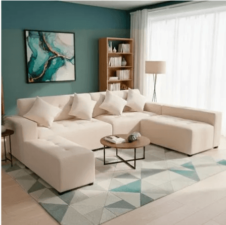A contemporary modular U-shaped sectional sofa with two chaises, upholstered in a light beige fabric. The design features deep button tufting on the seat cushions and chaises, and includes several matching throw pillows. It has a low-profile silhouette with dark, short block legs. — 3D model