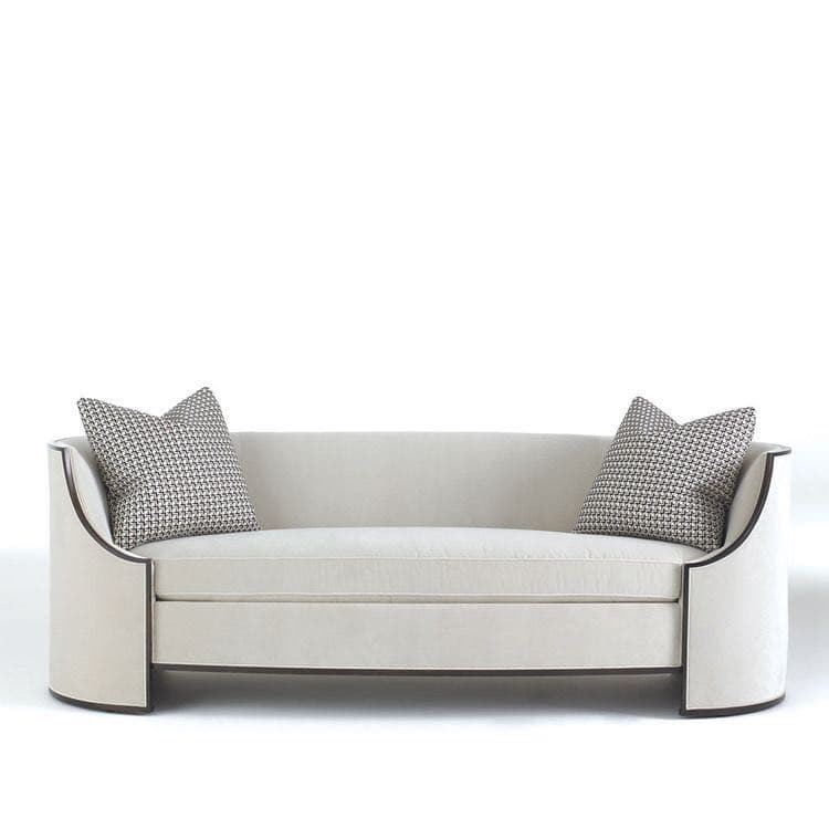 An off-white or cream-colored contemporary sofa with distinct rounded, enclosed armrests and a streamlined, skirted base. The armrests feature a dark wood trim detail. It has a single, long seat cushion and a fixed backrest, accompanied by two patterned throw pillows. — 3D model