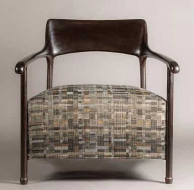 A modern armchair featuring a dark, sculptural wooden frame that forms the armrests, backrest, and legs. The armrests curve gracefully, extending from the backrest and supported by a leg structure. The seat is upholstered in a textured fabric with a multi-tonal geometric pattern in shades of beige, grey, and subtle orange. The chair presents a contemporary aesthetic with clean lines and organic shapes. — 3D model