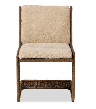 A chair with a rattan or wicker frame and upholstered seat and backrest with a sheepskin or faux sheepskin material. The frame has a woven texture. It features a low shelf or footrest integrated into the base, also constructed from woven material. — 3D model