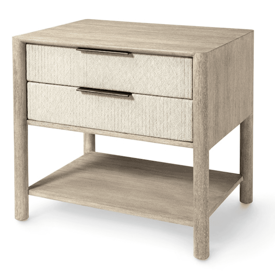 A contemporary nightstand featuring a light wood frame, two drawers with textured cream/beige fabric fronts, and an open lower shelf. The design includes slim, dark metal pull handles and rounded cylindrical legs. — 3D model