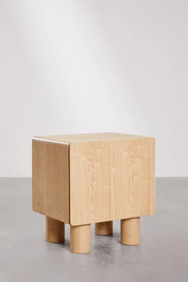 A contemporary nightstand with a cuboid main body and four cylindrical legs. The top and side panels have gently rounded edges. The grain of the wood is clearly visible, suggesting a natural wood construction. — 3D model