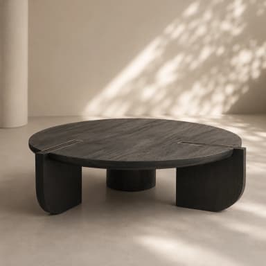 A contemporary round coffee table featuring a dark, possibly ebony-stained wood finish with visible grain. The tabletop is circular and incorporates four thin, rectangular brass inlays arranged symmetrically around the center. The base consists of multiple thick, architectural legs that combine curved and straight elements, providing stable support and contributing to the table's modern aesthetic. — 3D model