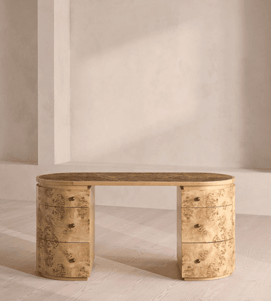 An elegant Art Deco-inspired writing desk featuring an oval tabletop with a dark, textured surface, supported by two rounded pedestals. Each pedestal houses multiple drawers, finished in a distinctive burl wood veneer with brass knob pulls. The design emphasizes curvilinear forms and luxurious materials. — 3D model