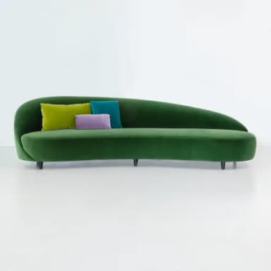 A modern chaise lounge upholstered in rich emerald green velvet, featuring a gracefully curved and ergonomic form. It has a low, integrated backrest that flows seamlessly into the seat and a footrest extension. The piece is supported by discreet, dark cylindrical legs, and three small, round accent pillows in lime green, purple, and teal are placed on the backrest. — 3D model
