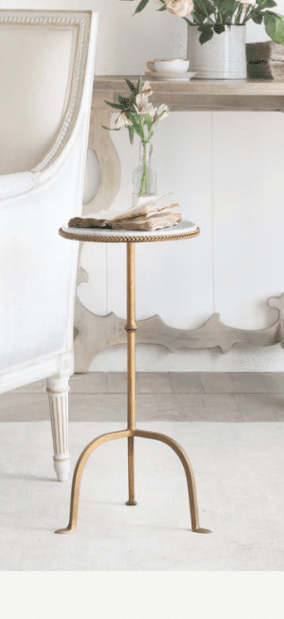 A round side table with a white marble top and a gold-finished metal base. The base has a slender, adjustable central column and three gracefully curved legs that splay outwards. The edge of the marble top is accented with a decorative braided trim. — 3D model