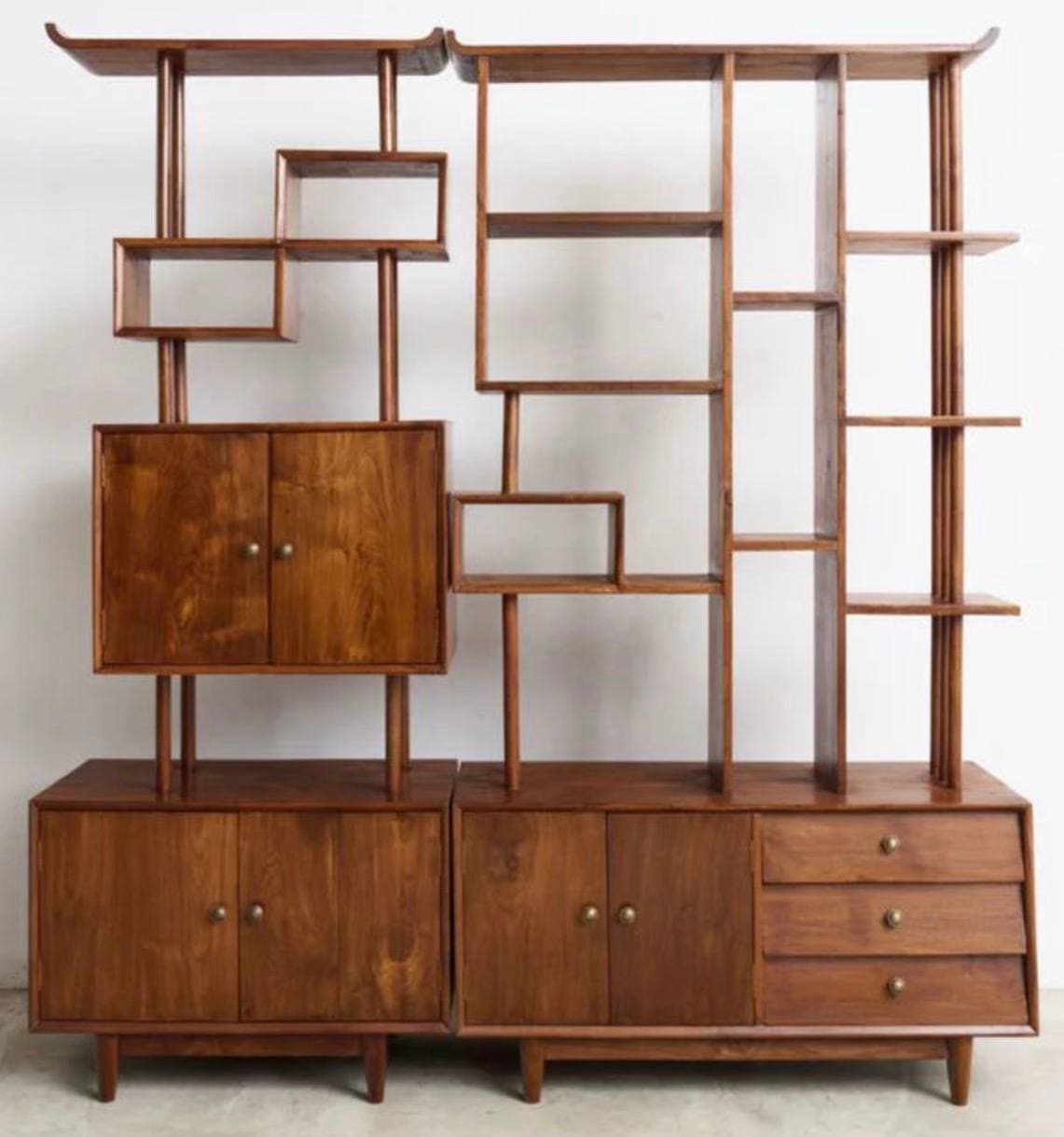 A mid-century modern style modular shelving unit made of wood, featuring a combination of open display shelves, enclosed cabinets with doors, and pull-out drawers. The unit stands on splayed legs and has a warm brown finish. — 3D model
