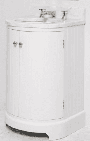 A white vanity cabinet with a curved front, featuring two doors with silver knobs. The cabinet is topped with a white marble countertop integrated with a sink and a chrome faucet set. The vertical paneling on the doors and sides suggests a traditional or shaker style. The base has a decorative, curved plinth. — 3D model