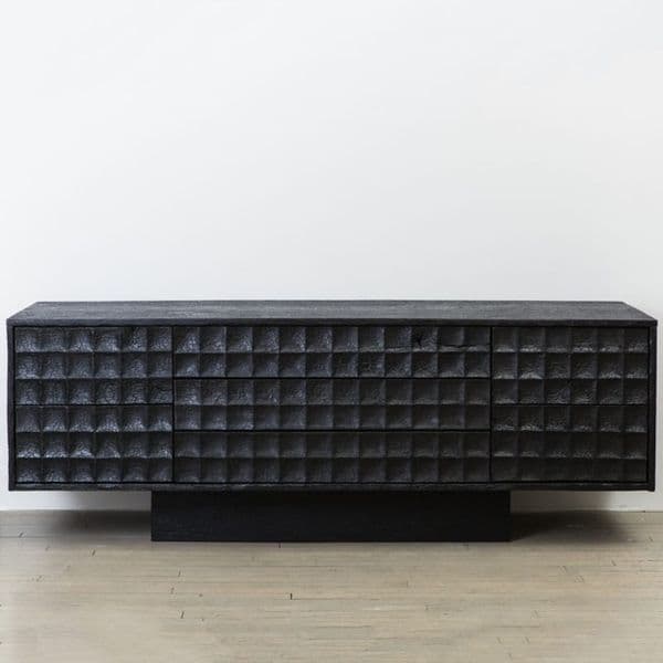 A long, low dresser with a textured front. The front features a repeating geometric pattern of small, carved squares. It has multiple drawers, appearing to have three visible drawers on the left and a door or another drawer on the right. The dresser is supported by a solid, rectangular base. — 3D model