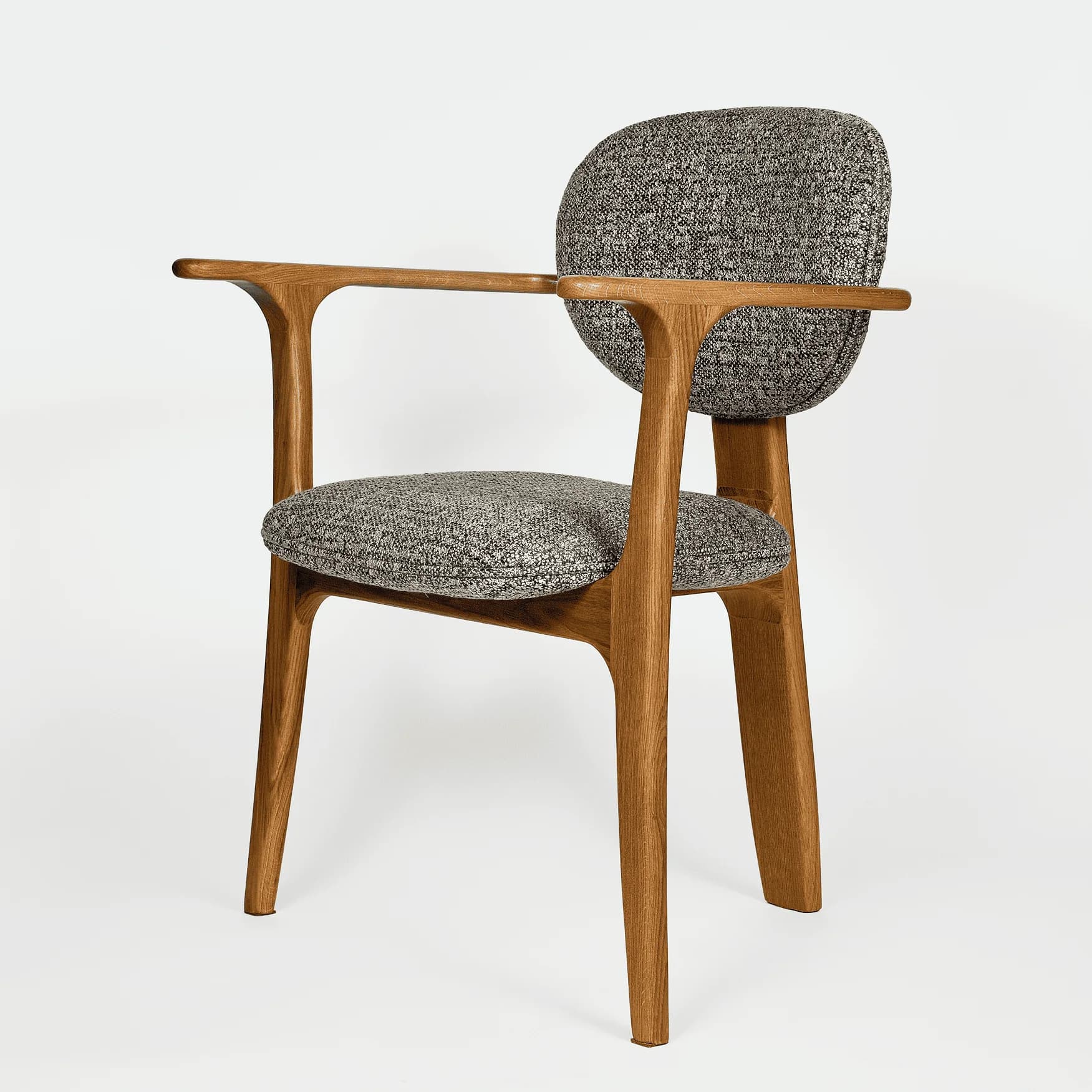 A contemporary armchair featuring a solid wood frame with a clear finish, upholstered in a speckled grey fabric. The chair has elegantly sculpted armrests integrated into the frame, and a rounded, separate backrest. The legs are slightly tapered, contributing to its modern aesthetic. — 3D model