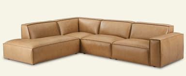 A modular sectional sofa with a left-hand facing chaise lounge, upholstered in camel-colored leather. The design features clean lines, square arms, and visible piping details along the edges of the cushions and frame, giving it a contemporary minimalist aesthetic. The sofa modules are designed to connect seamlessly, and it rests on small, recessed feet. — 3D model