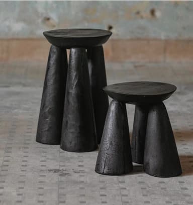A minimalist stool featuring a circular flat top seat and three robust conical legs, all crafted from solid wood and finished in a matte black, showcasing subtle wood grain texture. — 3D model