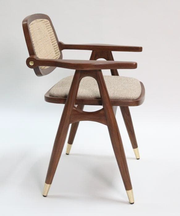 A modern wooden dining armchair featuring a cane back, upholstered seat, and tapered legs with brass caps. — 3D model