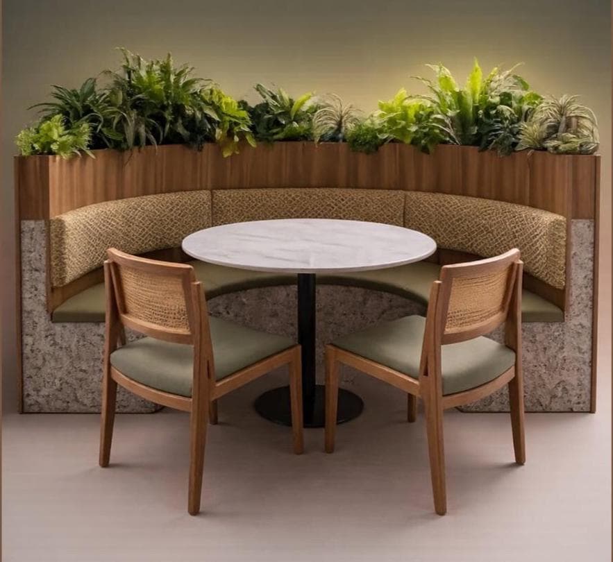 A semi-circular booth seating arrangement designed for a dining or lounge area, featuring integrated planters along the top edge and two accompanying chairs. The booth has a curved backrest upholstered in a textured fabric and a base with a speckled, stone-like finish. Two side chairs with wooden frames and woven cane backs complement the booth, each with a cushioned seat upholstered in a solid green fabric. A circular marble-top table with a black pedestal base is centrally positioned within the seating area. — 3D model