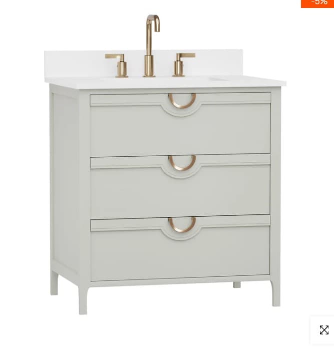 A freestanding bathroom vanity with a white countertop, featuring a modern gold faucet and a sink. The vanity unit has three drawers with recessed fronts and decorative gold semi-circular handles. The unit is supported by four slender, angled legs. — 3D model
