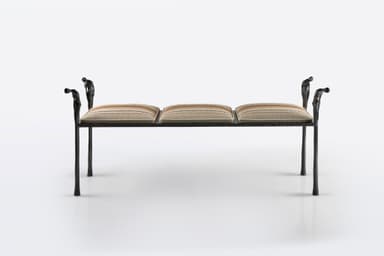 A distinctive figural wrought iron bench featuring a dark, textured metal frame with decorative uprights sculpted as human figures, supporting segmented upholstered cushions with a striped pattern. The bench has four slender legs and decorative arm-like elements at each end, also featuring figural motifs. — 3D model