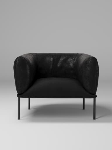 A contemporary armchair with a low profile, featuring a rounded, enveloping back and armrests. The upholstery has a textured appearance, suggesting leather or a high-quality fabric. It is supported by four slender, dark-colored legs that elevate the seat from the floor. — 3D model