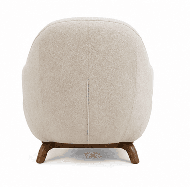 An upholstered armchair featuring a plush, rounded silhouette. The chair is covered in a textured cream-colored boucle fabric. It has integrated, softly curved arms and a continuous backrest. The seat base includes subtle vertical channel tufting. The chair rests on short, splayed dark wood legs. A matching rectangular lumbar pillow is included. — 3D model