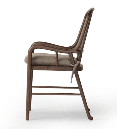 A wooden armchair with a curved backrest composed of vertical spindles. It features rounded armrests and a cushioned seat. The frame is constructed from dark wood, and the cushion is upholstered in a neutral-toned fabric. — 3D model