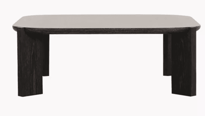 A modern coffee table featuring a rectangular top with gently rounded corners, likely crafted from concrete or a similar composite material in a light grey tone. The robust base consists of two thick, dark-stained wooden block legs, exhibiting visible wood grain, which provide sturdy support and a minimalist aesthetic. The table's low profile is characteristic of a coffee table, designed for placement in a living area. — 3D model