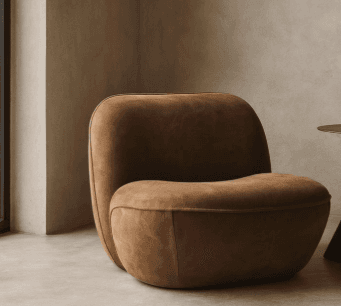 A modern armchair with a distinctive, rounded, and organic form. The chair features a plush, upholstered seat and backrest with no visible frame. Its silhouette is soft and inviting, designed for comfort and visual appeal. The armrests are integrated into the overall shape, providing a continuous flow. — 3D model