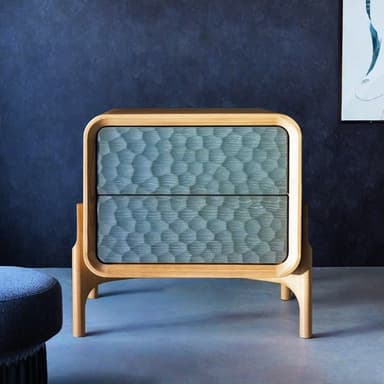 A modern two-drawer nightstand featuring a light-toned wooden frame with prominently rounded edges. The unit stands on distinctive, sculpted wooden legs that extend upwards to support the cabinet body. The two drawers have flat fronts finished in a textured, dark teal or blue-green color, contrasting with the natural wood grain. — 3D model