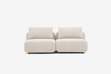 A sectional sofa unit with a low profile, upholstered in a textured, light-colored fabric. The design features rounded armrests and seat cushions, with a modular appearance. Visible stitching details indicate precise construction. The sofa has a contemporary, minimalist aesthetic. — 3D model