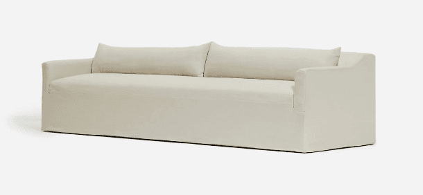 A contemporary sofa featuring an ecru-colored slipcover that gives it a relaxed and casual appearance. The sofa has clean lines with structured track arms and a low-profile base. It includes two loose back cushions, suggesting comfort and ease of maintenance. The overall aesthetic is minimalist and modern, suitable for various interior designs. — 3D model
