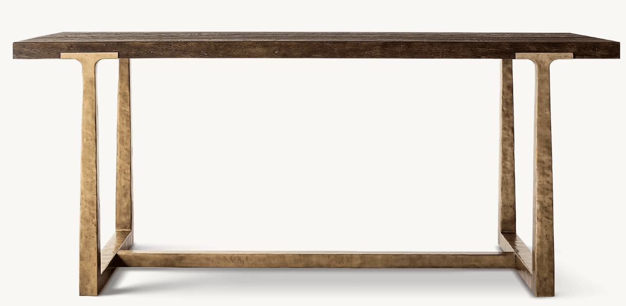 A console table featuring a dark stained wooden top with a pronounced grain texture and a rough-hewn appearance. The base is constructed from metal with a distressed, antique brass-like finish, exhibiting a textured, hammered surface. The legs are elongated and rectangular, connected by a lower horizontal stretcher, creating a minimalist yet robust structure. — 3D model