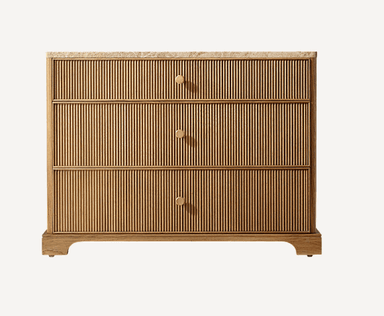 A modern chest of drawers featuring three full-width drawers with reeded fronts, a beige marble top, and small circular brass pulls. The frame is made of light-toned wood and it stands on a recessed plinth base. — 3D model