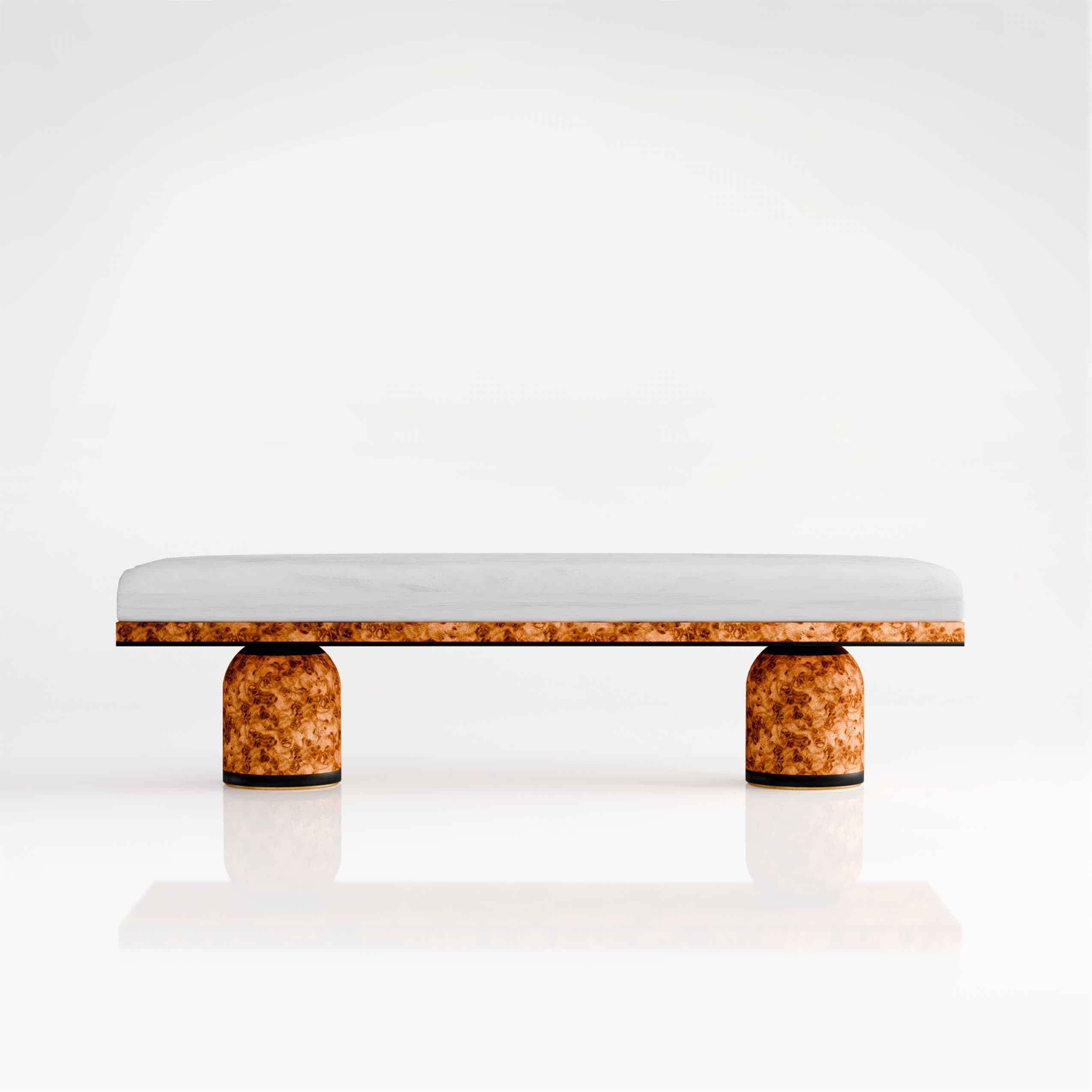 A low-profile bench featuring a cushioned top and cylindrical legs. The top appears to be upholstered in a light-colored, possibly fabric material. The legs are cylindrical and constructed from a material with a prominent wood grain pattern, likely burl wood veneer, and have a dark base band. The bench is presented against a plain white background, suggesting a studio or product photography setting. — 3D model
