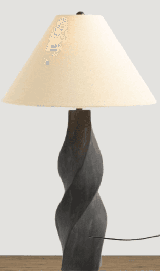 A table lamp featuring a dark, twisted column-shaped base and a conical, off-white fabric shade. The lamp is positioned on a light wooden surface. — 3D model