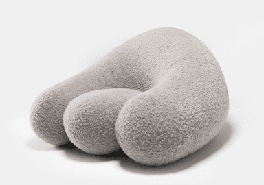 A light grey, upholstered, organically shaped piece of furniture, resembling a large smooth pebble or rock. Its surface appears to be a soft, textured fabric. — 3D model
