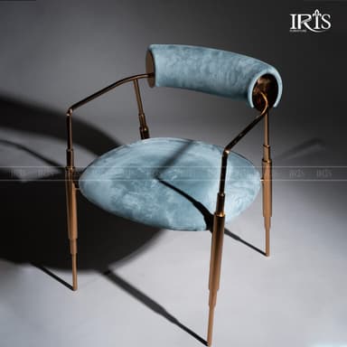 A contemporary armchair featuring light blue velvet upholstery on its circular seat and cylindrical bolster backrest, supported by a slender polished rose gold-tone metal frame and tapered legs. — 3D model