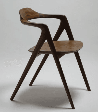 A modern wooden chair with a curved backrest and seat. The chair features a four-legged base with tapered legs and integrated armrests that flow seamlessly into the backrest. The design emphasizes organic curves and a minimalist aesthetic. — 3D model