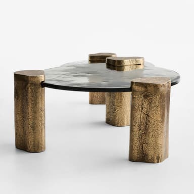 A contemporary coffee table with a circular, smoked glass top supported by four uniquely shaped, textured metallic legs. The legs appear to be cylindrical with irregular, rough surfaces and are finished in a bronze-like hue. The overall design is minimalist yet impactful, with the textured legs contrasting with the smooth glass. — 3D model
