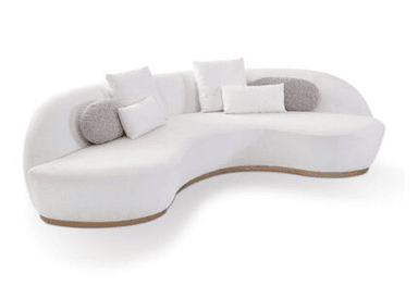 A contemporary curved sectional sofa upholstered in a white, textured bouclé-like fabric, featuring a sinuous, organic silhouette. The sofa rests on a visible natural wood plinth base that follows its undulating form. It includes several matching and contrasting throw pillows in white and grey tones, enhancing its comfort and modern aesthetic. The design prioritizes soft lines and a seamless appearance, with integrated backrests. — 3D model