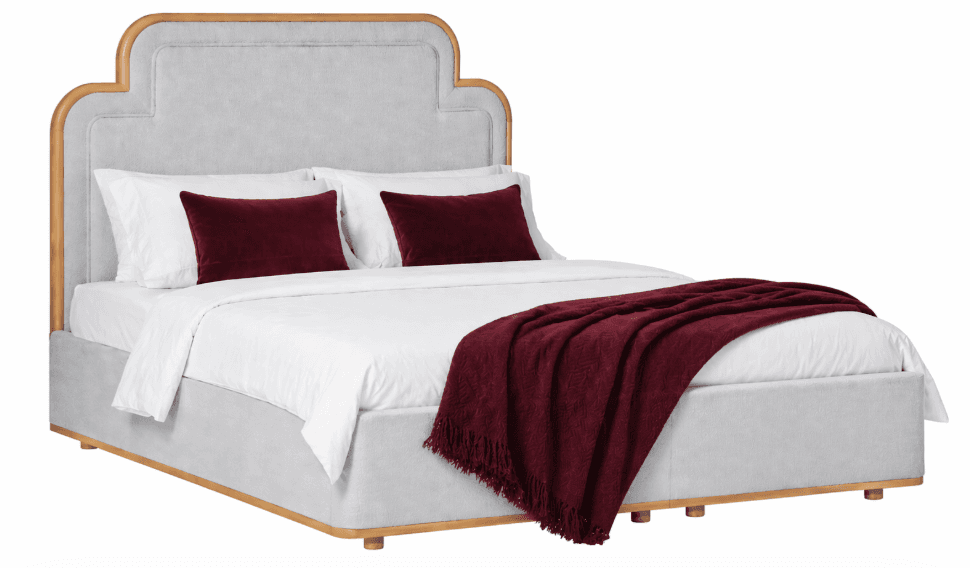 A upholstered bed frame with a distinctively shaped headboard featuring a wooden trim. The bed is dressed with white linens, two white pillows, two decorative burgundy velvet lumbar pillows, and a burgundy throw blanket draped over the foot of the bed. The bed frame is upholstered in a light gray fabric and has a visible wooden base and legs. — 3D model